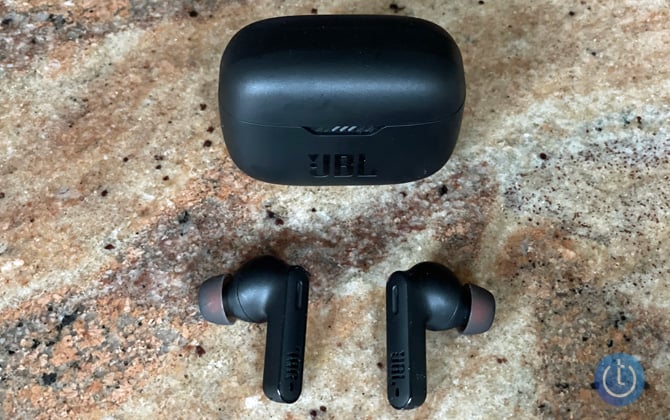 JBL TUNE230NC earbuds with case on granite surface.
