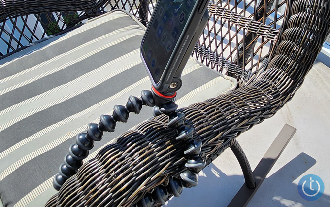 GripTight GorillaPod for MagSafe attached to a wicker chair arm with an iPhone in portrait mode.