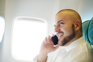 Man making a phone call on a plane