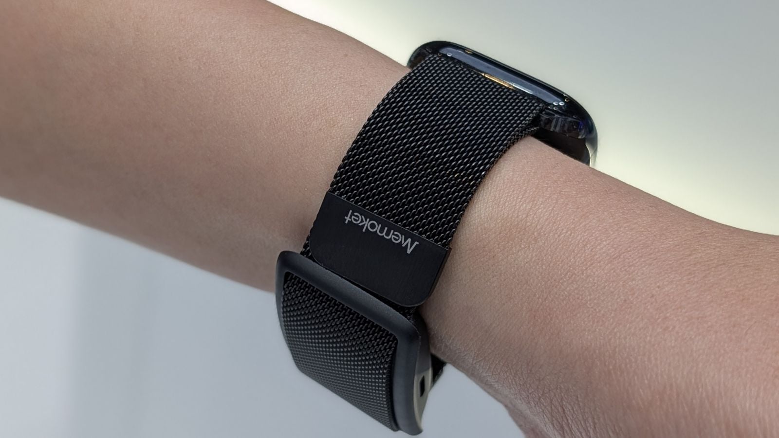 Memoket Gem AI wristband mounted on the same band as an Apple Watch