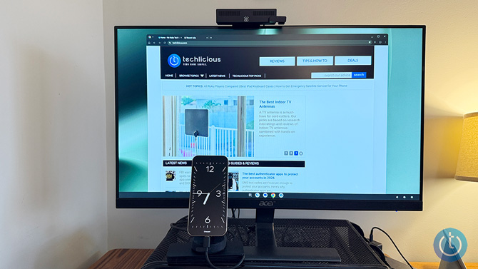 A Google Pixel phone connected to a monitor displays the Techlicious website.