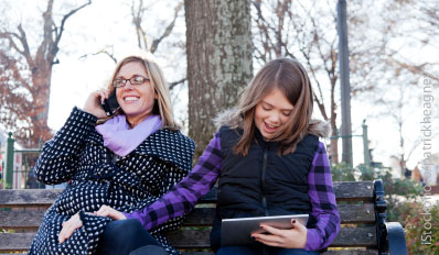 Mother and daughter using mobile devices