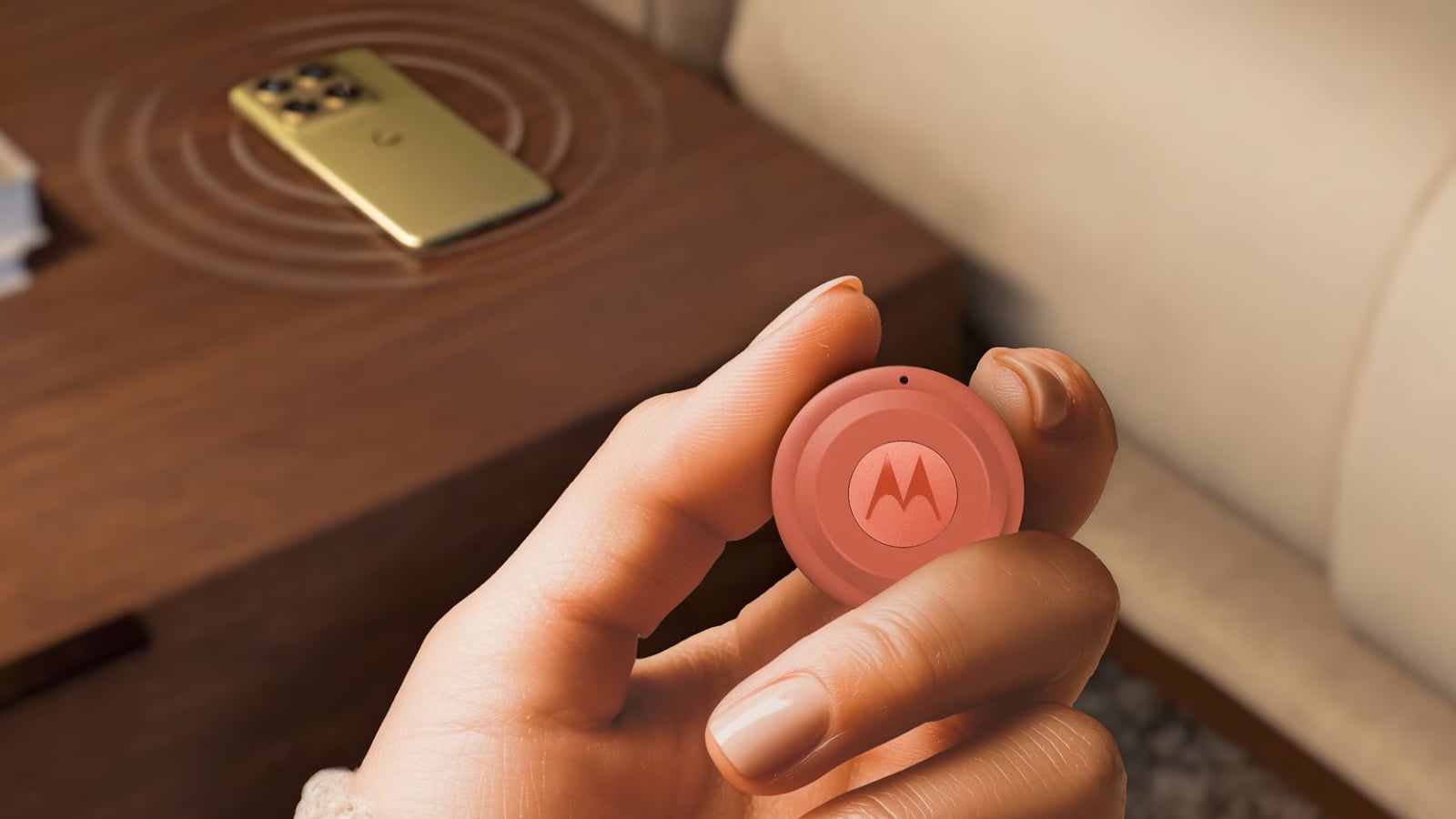 Moto Tag 2 in hand with a phone in the background