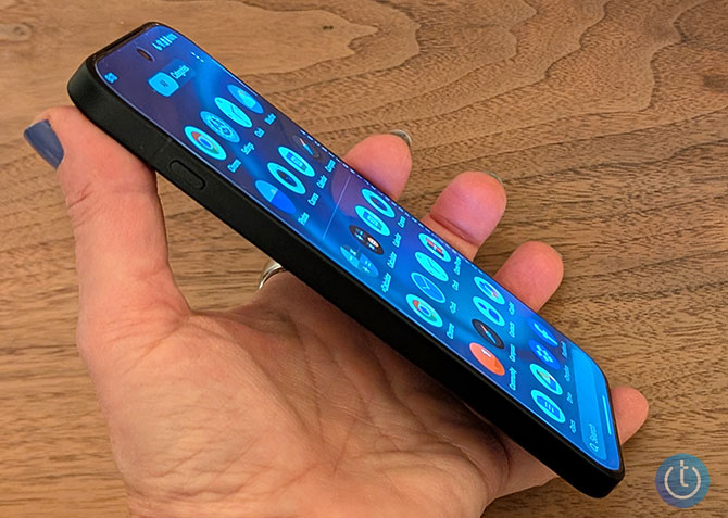 The OnePlus 15 is shown from the side in the author's hand.