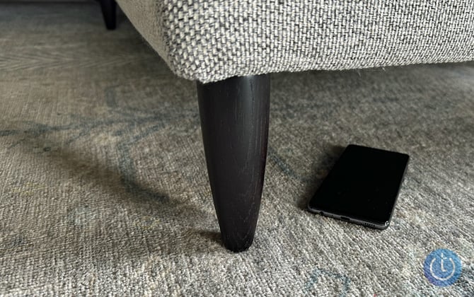 Phone on the floor under a sofa.