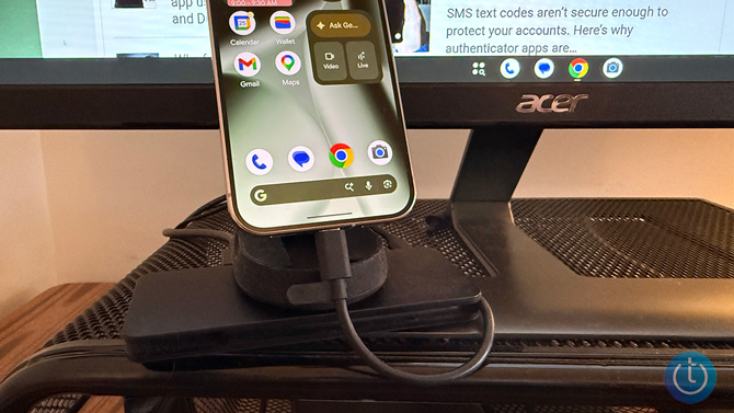 A closeup of the Pixel 10 Pro plugged into a USB-C hub with monitor in the background.