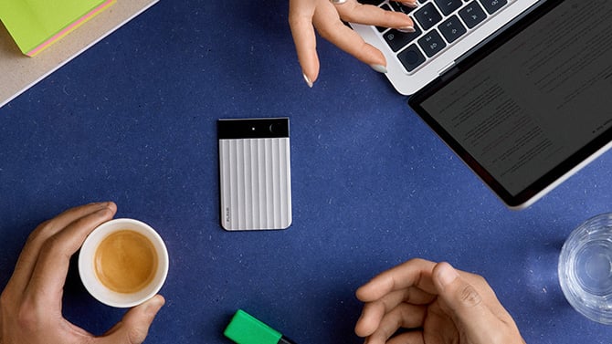 Plaud Note Pro on a table with a white light glowing on the display.