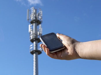 Smartphone held next to cell tower