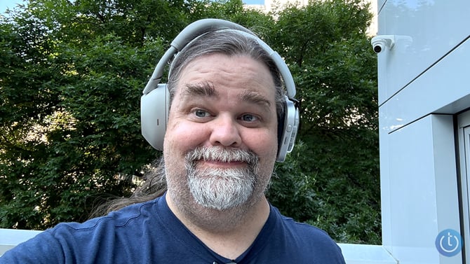 Adam Doud wears both headphones with the Sony shown on the left and the Nothing on the right.