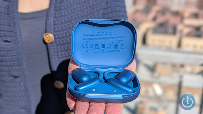 The Soundcore AeroFit 2 sit in their charging case.