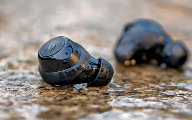 Anker Soundcord Life Dot 2 true wireless earbuds on granite surface and sprinkled with water