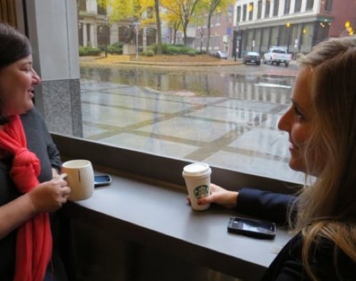 Women using wireless phone charging stations at Starbucks