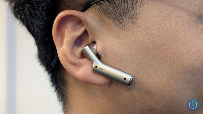 Closeup of small, silver earbud placed in the ear
