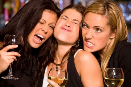 Women at bar making faces